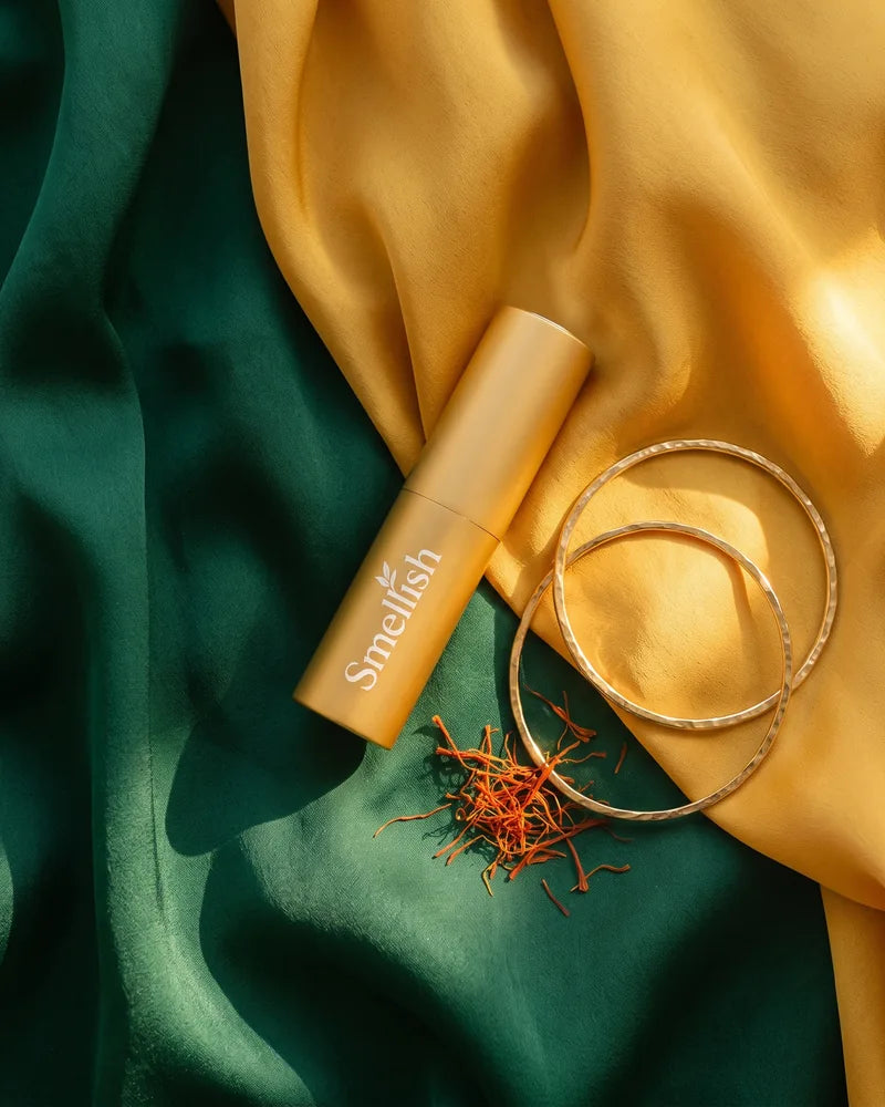 Gouden Smellish twist-up op smaragdgroene en saffraangele zijde met gouden armbanden en saffraandraadjes